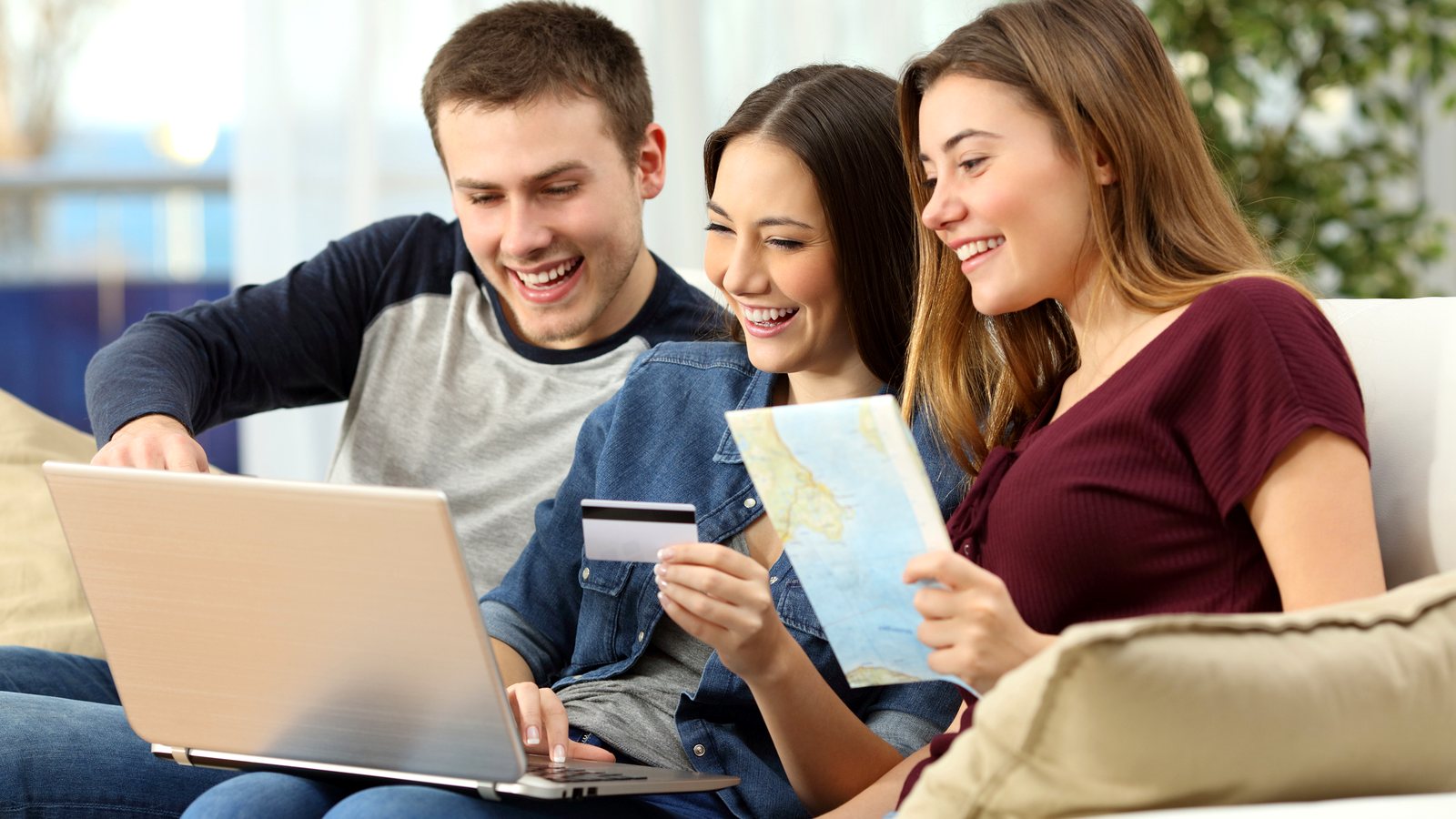 Three friends booking a trip on a laptop