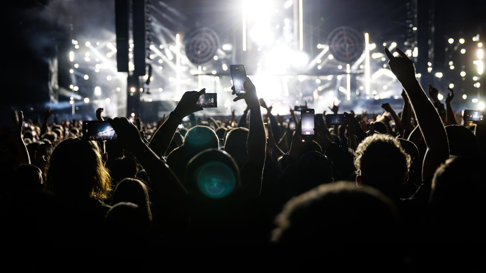 Crowd on a packed dance floor with hands raised