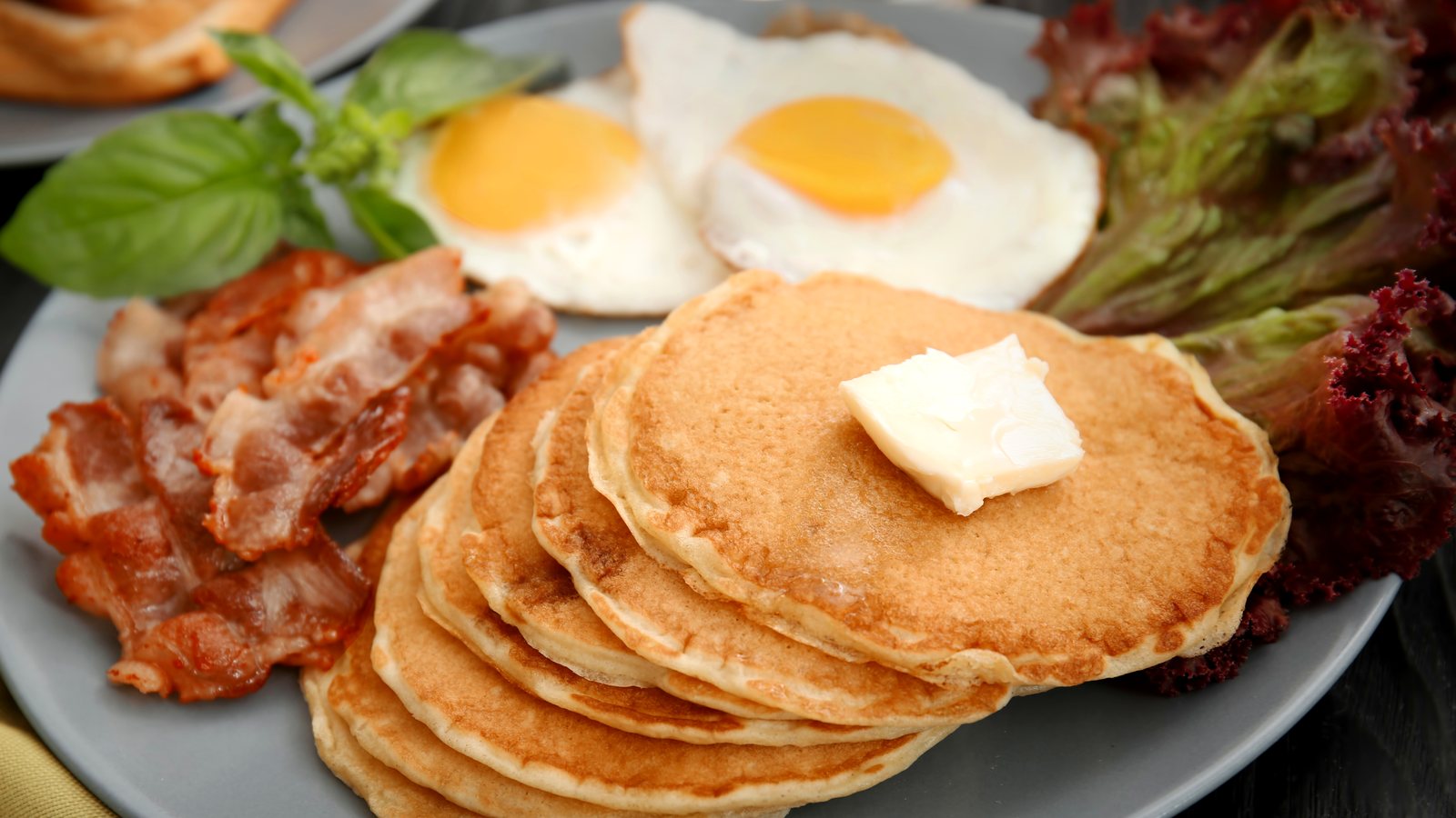 Breakfast plate with eggs, pancakes, and bacon