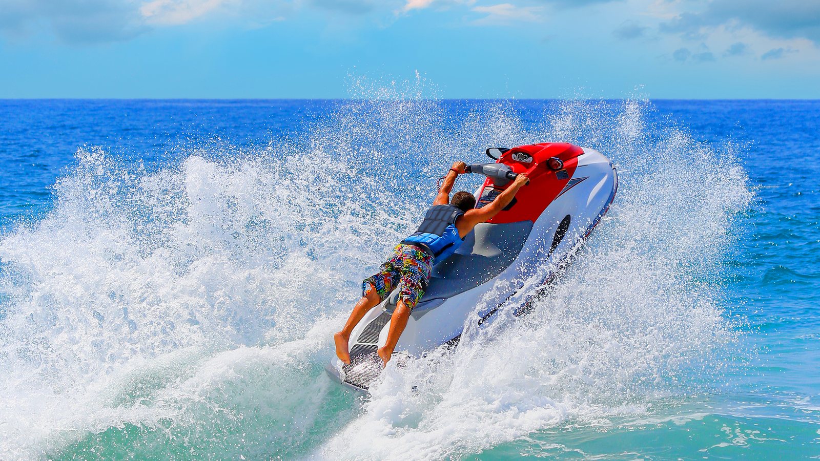 Jet ski jumping a wave on turquoise water