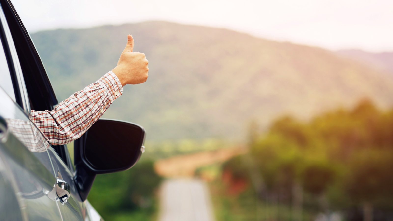 Thumbs up out the window on a road trip