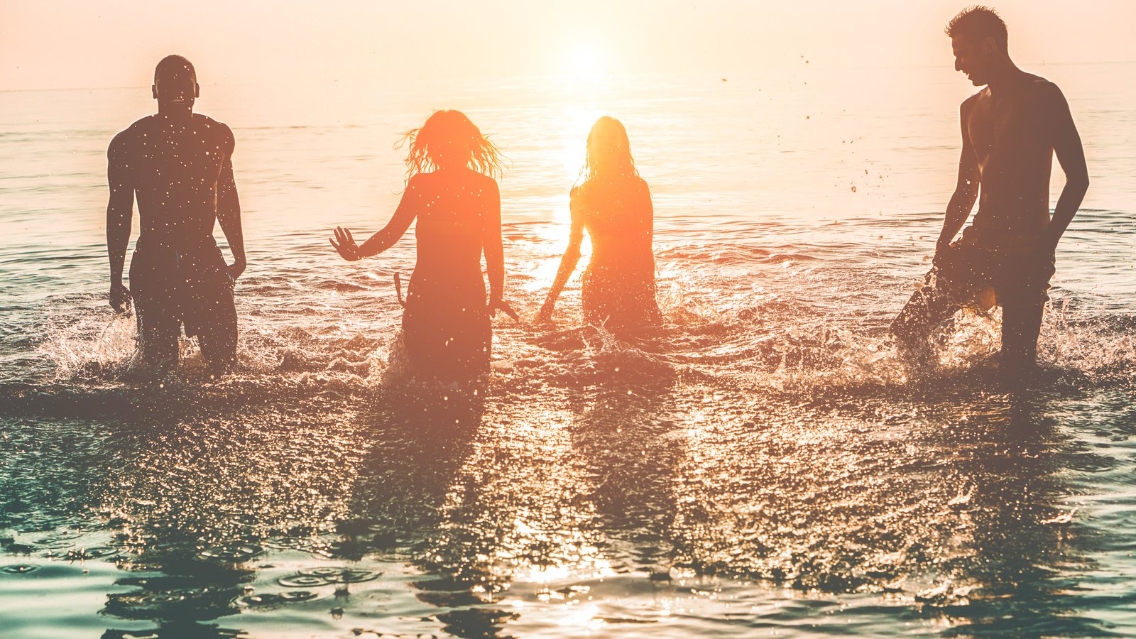 Friends in the water at sunset on a Gulf beach — Panama City Beach spring break